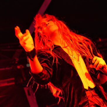 Kamijo jogando rosas para a plateia durante o show