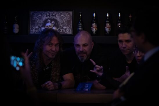 Membros da banda recebendo presentes e autografando discos